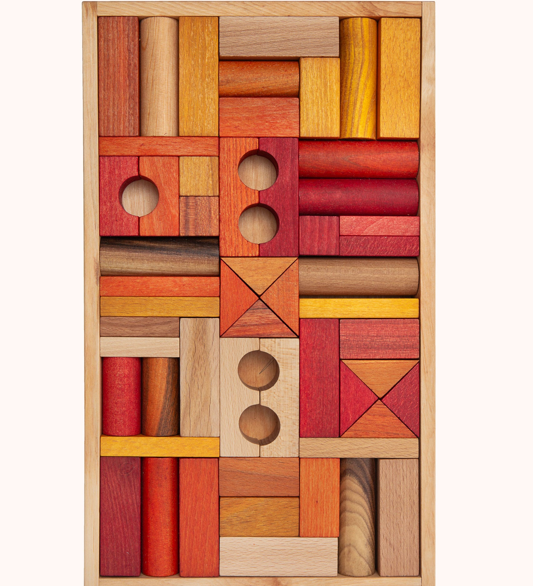 Wooden Story 54 Warm Blocks in Tray on a plain background. The set features various shapes of wooden clocks in warm orange, natural and yellow shades. 