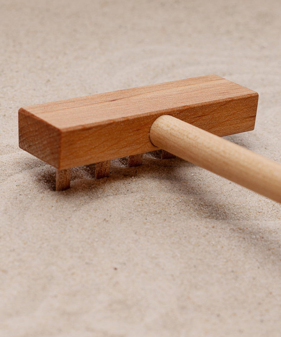 A close up of the wooden taking tool from the Wooden Story Montessori Sand Tray and Accessories. 