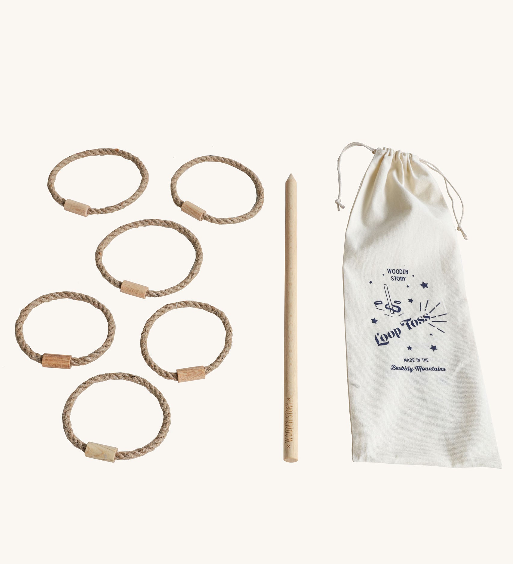 Wooden Story Traditional Style Wooden Loop Toss Game laid out on a plain background. The set includes 5 natural rope hoops with wooden connectors with a wooden stick and a cotton drawstring storage bag.  