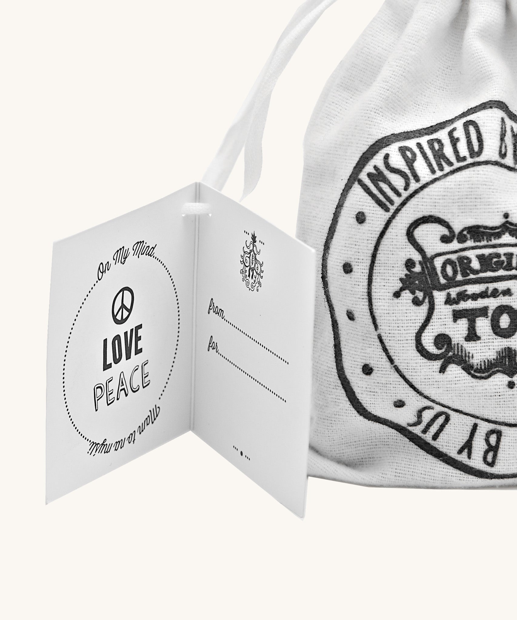 Close up of the Wooden Story Peace & Love Blocks canvas drawstring gift bag and gift-tag.