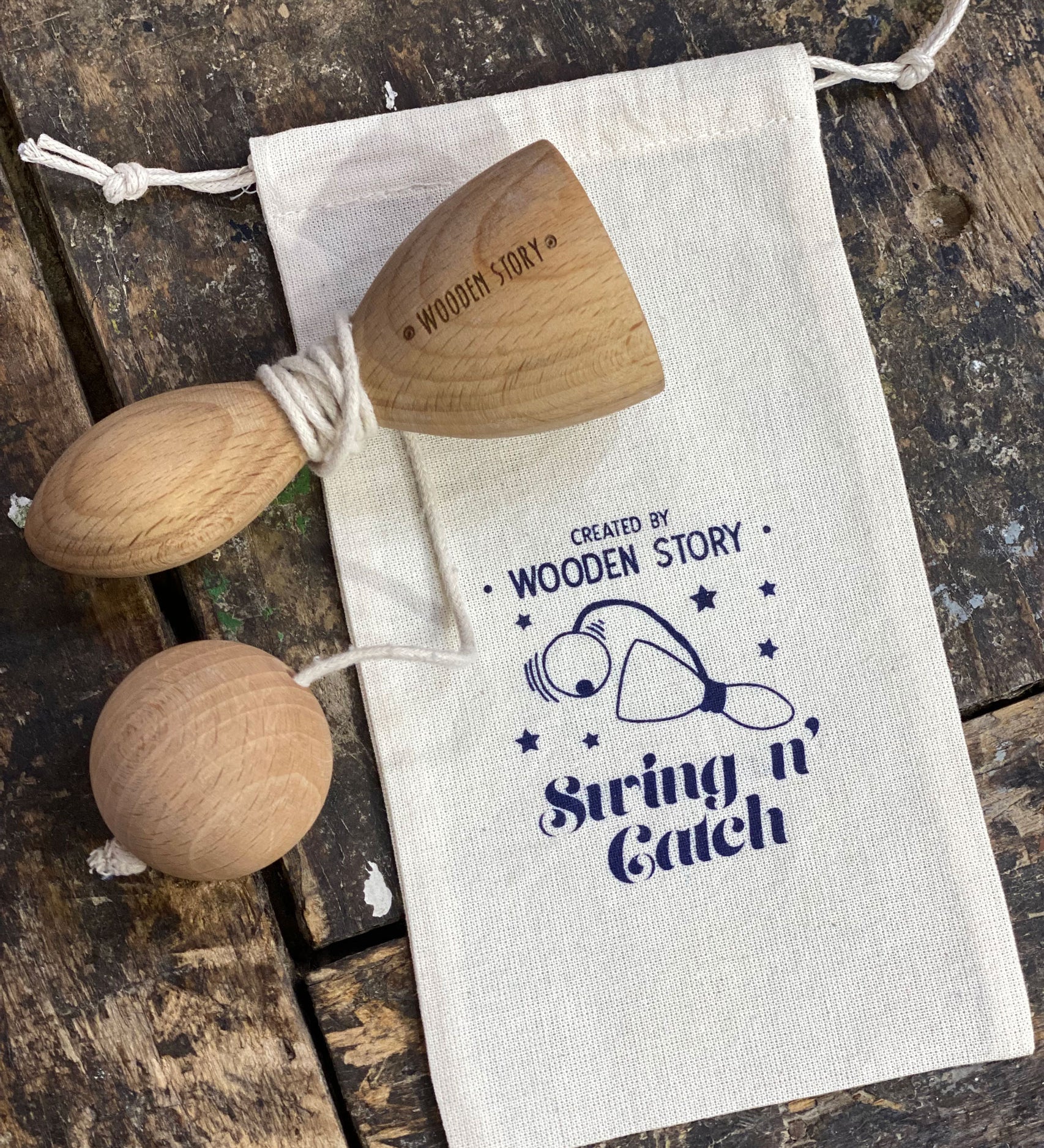 Wooden Story Traditional Style Swing N' Catch cup and ball Toy with a cotton drawstring storage bag.