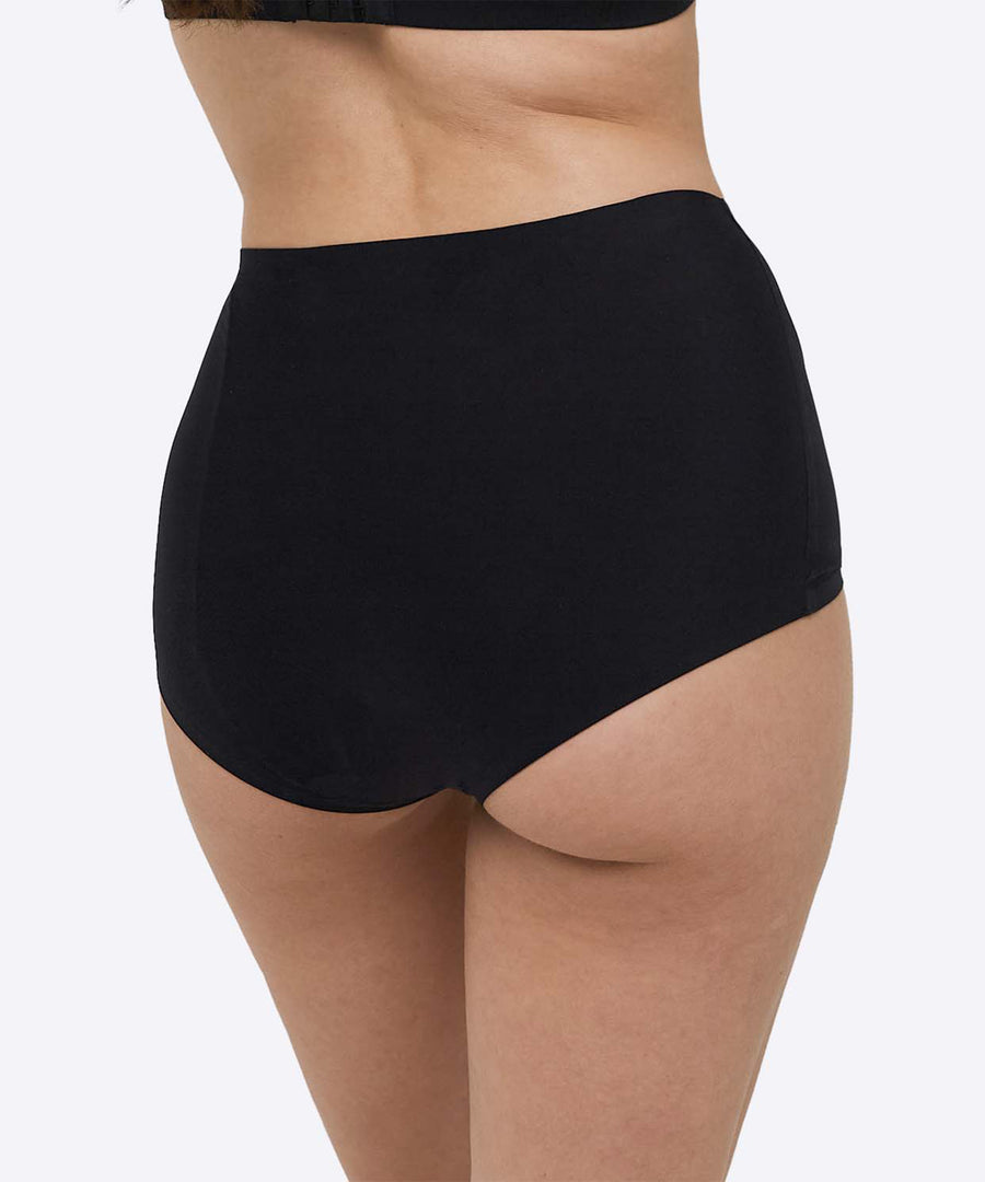 A person wearing the WUKA Stretch Boxer Shorts Heavy Flow - Black