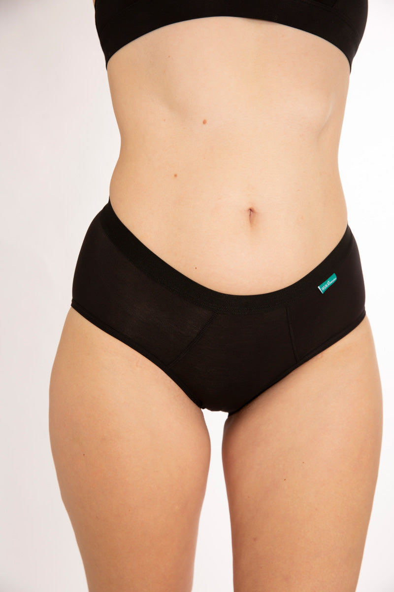 Close up of woman wearing the WUKA eco-friendly midi brief everyday pants on a white background