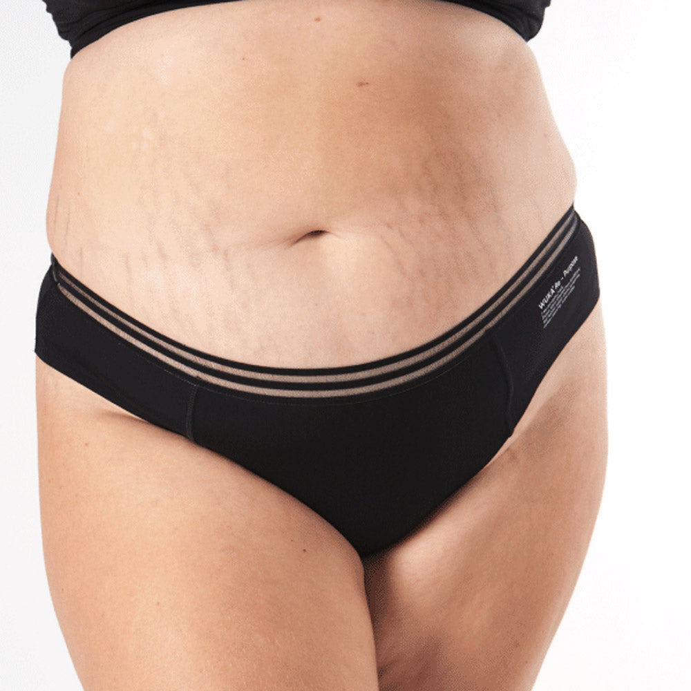 Close up of woman stood on a white background wearing the eco-friendly WUKA french bikini medium flow period pants