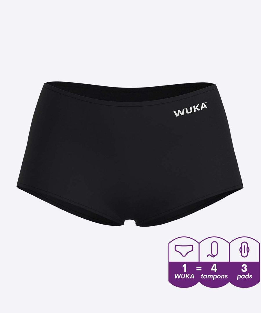 A person showing the stretch material of the WUKA Teen Stretch Boxer Shorts Heavy Flow - Black