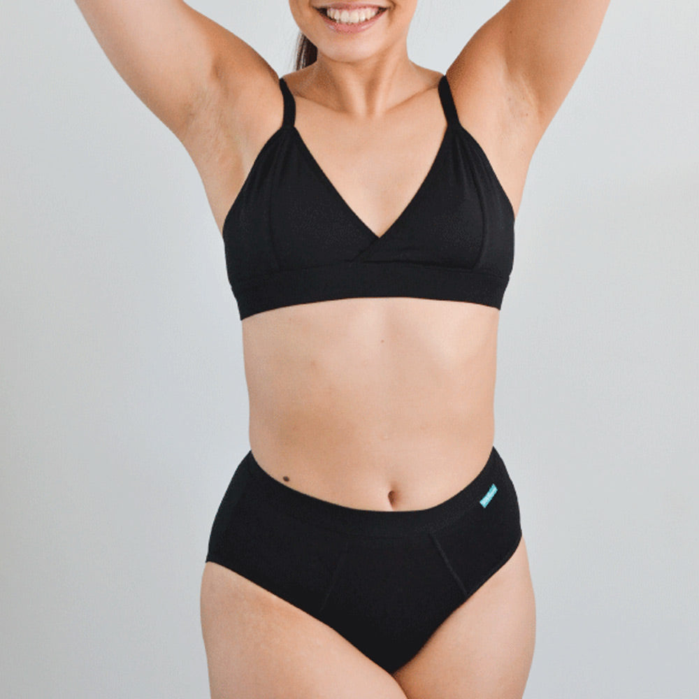 Woman stood on a grey background wearing the eco-friendly WUKA tencel midi underwear