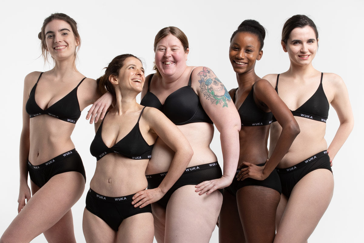 Women stood in a line wearing the WUKA eco-friendly midi brief sanitary underwear on a white background